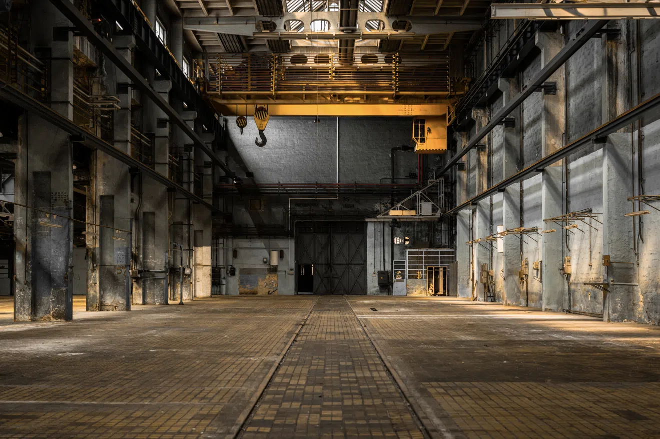 A inside view photo of a very cool old heavy industrial warehouse with crane service.